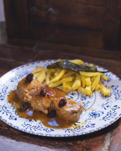 Plato de solomillo a la pasa moscatel con guarnición de patatas fritas y pimiento