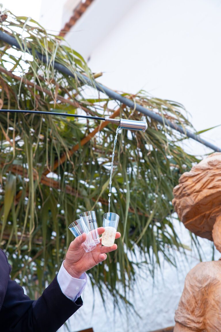 La mano de un venenciador trasegando vino blanco de Moclinejo en la Fiesta de Viñeros