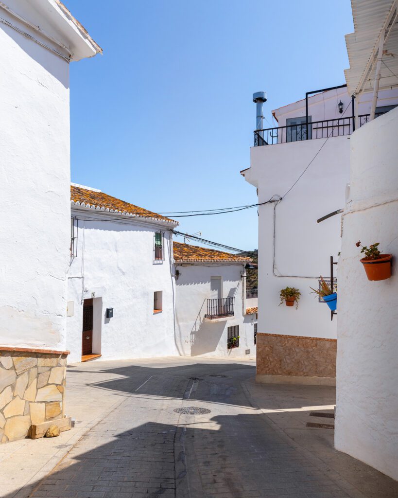 Calle de Moclinejo con casas blancas en un día soleado