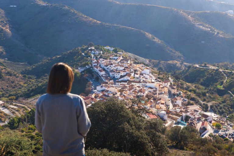 Mujer senderista mirando hacia Moclinejo en una ruta de senderismo
